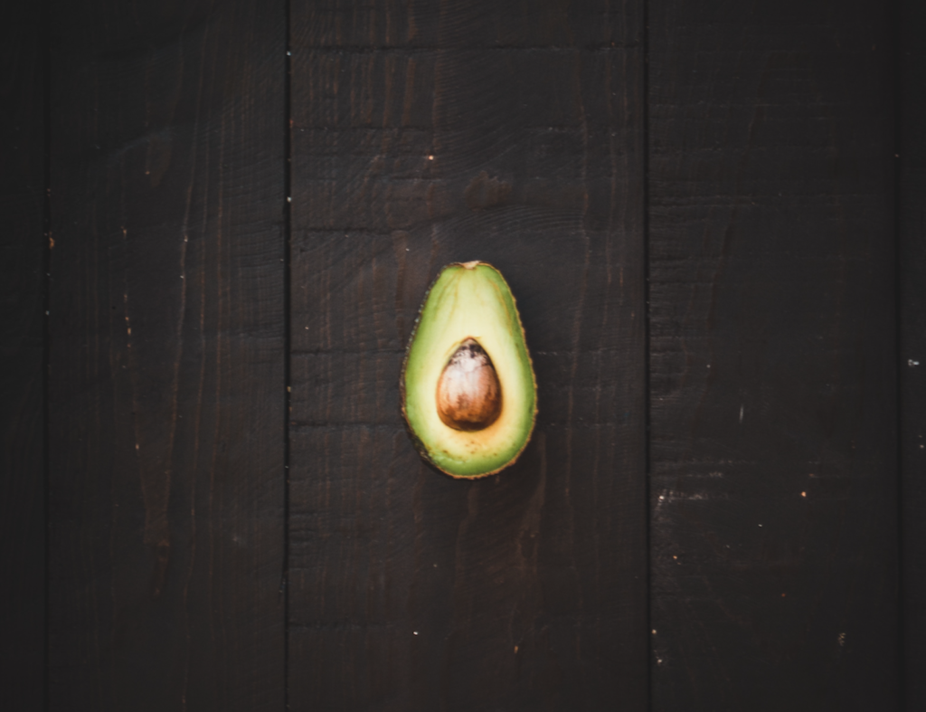 Cut avocado on wooden background