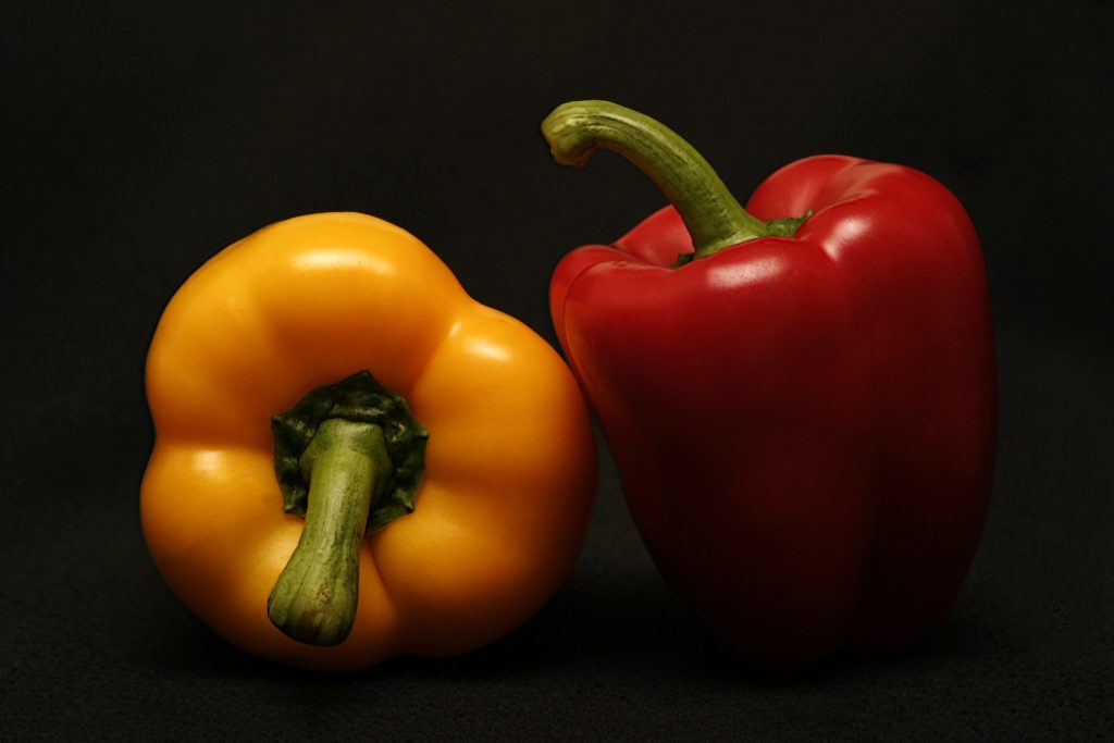 red and yellow bell peppers on a black background