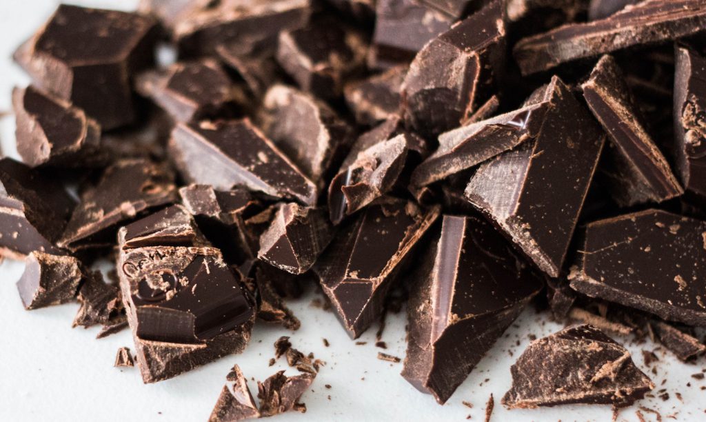 bits of chopped dark chocolate on a white surface