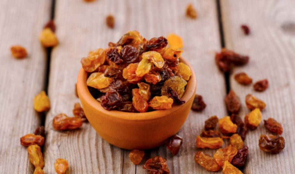 bowl full of raisins on a wooden surface