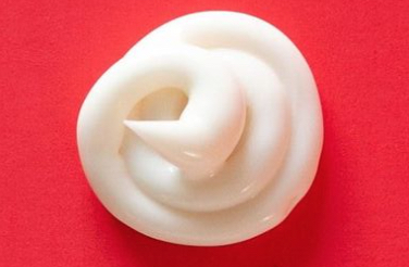 A dollop of ball lotion on a red surface