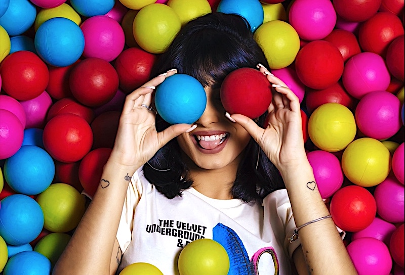 Women in a ball pit holding 2 balls