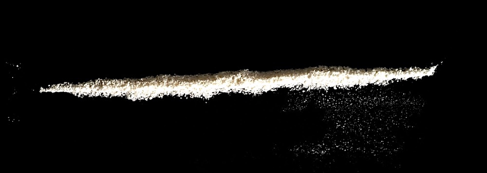 A line of "talc" powder on a black surface.