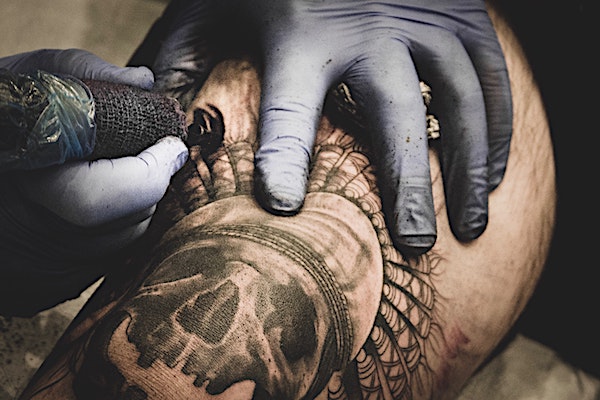 A man getting a black and grey tattoo.