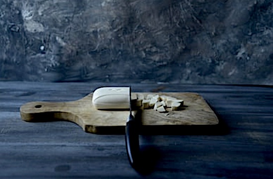 A bar of soap being cut on a cutting board