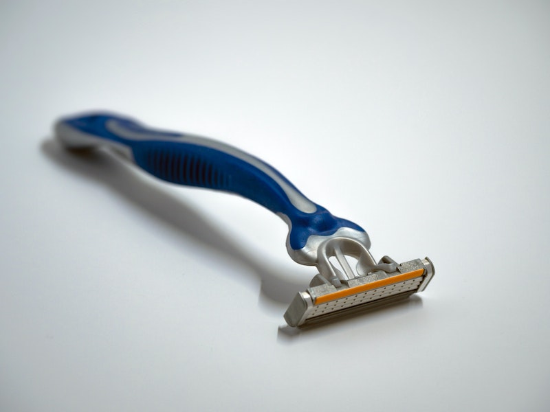 A blue razor on a white surface