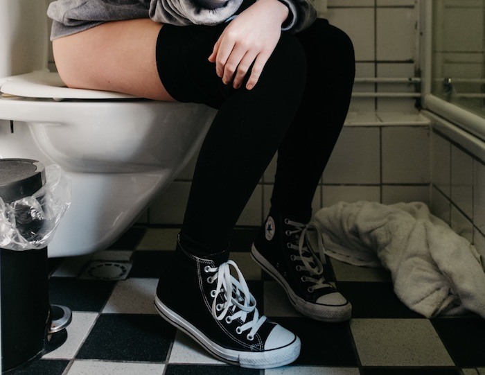 Person sitting on toilet