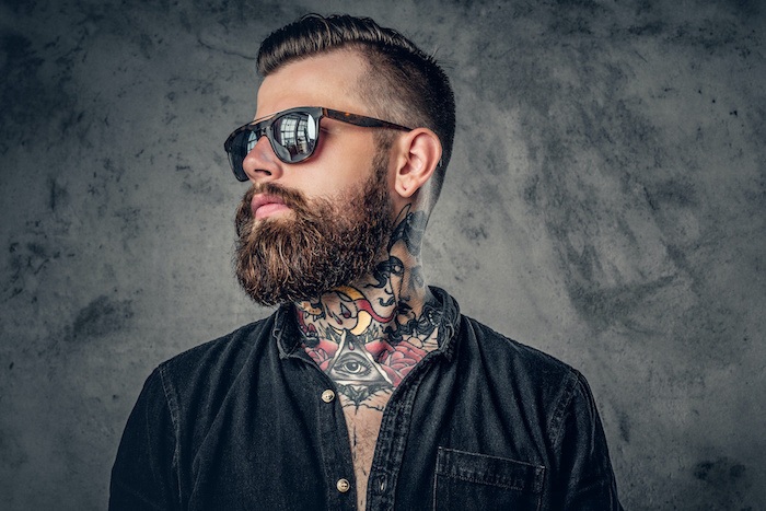 Man with beard, tattoos, and wearing sunglasses
